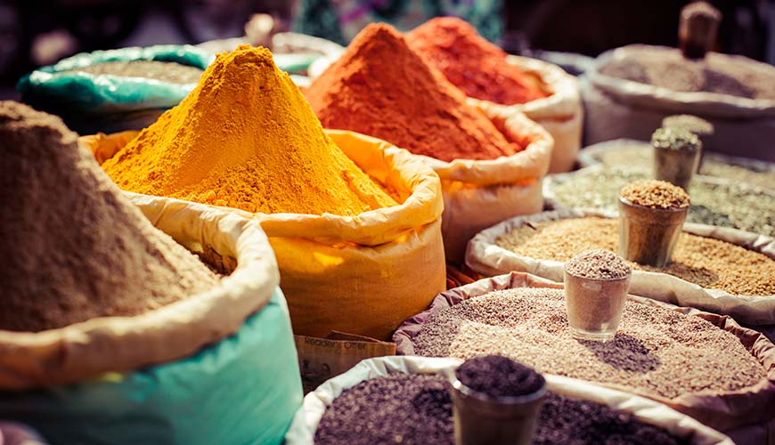 colourful bags of spices at the spice market in delhi in india on a group tour to india