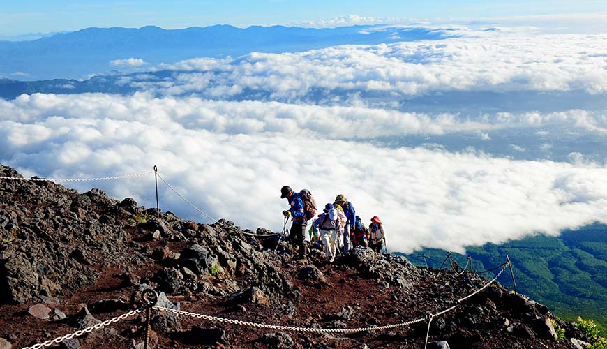 group of people climbing to the top of mount fuji