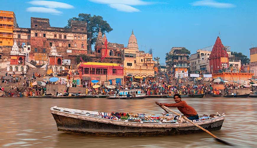 man rowing a boat on the holy river ganges in varanasi india