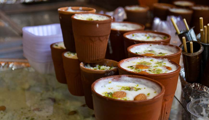 a pile of lassi yoghurt drinks in ceramic mugs in india