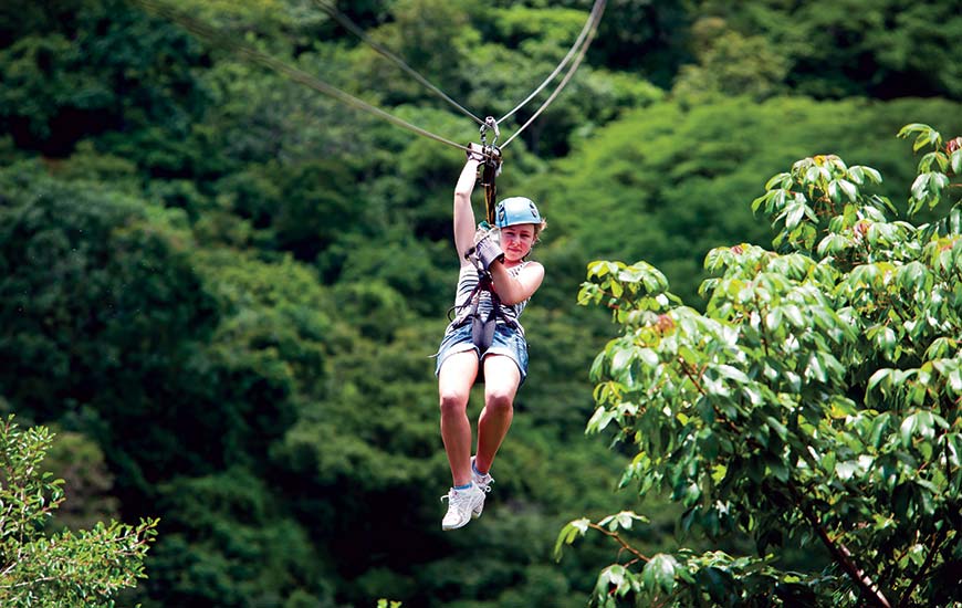 girl zip lining through the monteverde cloud forest in costa rica on a group tour