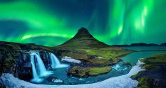 green northern lights aurora borealis in iceland with waterfall and kirkjufell mountain in snaefellsnes peninsula