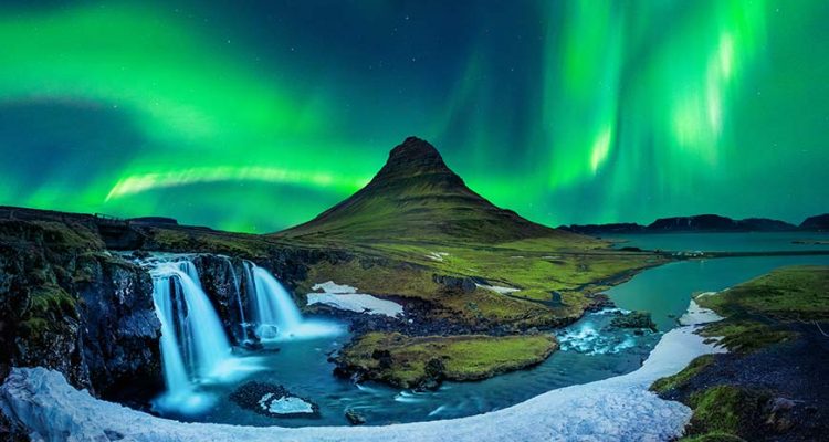 green northern lights aurora borealis in iceland with waterfall and kirkjufell mountain in snaefellsnes peninsula