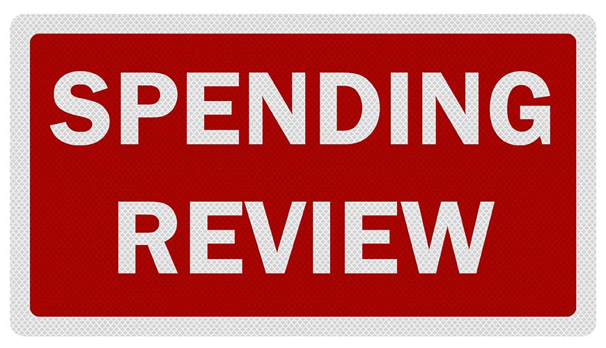 "spending review" sign with white writing and a red background