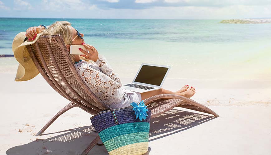 woman working on the beach whilst on holiday to earn some extra money, travelling on a budget