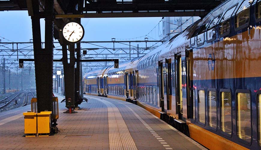 train at the train station in amsterdam early morning hours, travelling on a budget
