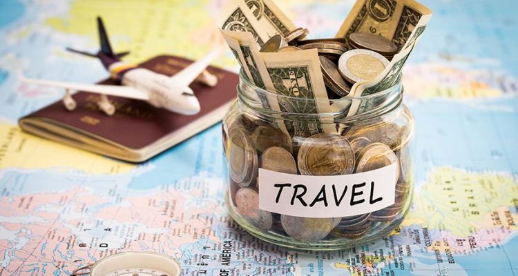 travel savings jar on a world map with passport and model airplane