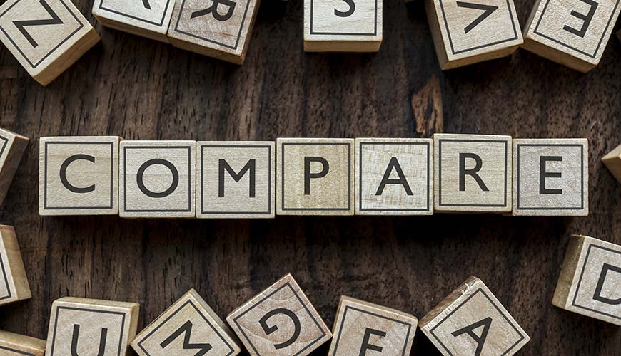 wooden letters aligned to say "compare" on table, save money for travelling