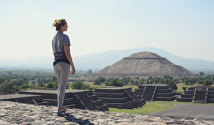Young woman standing in front of Teotihuacan in Mexico enjoying one of the best places to travel in December