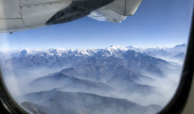 View of the Himalayan and Everest mountain range from inside the cabin of a flight