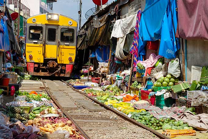 An image of the train running through Maeklong food market in Bangkok