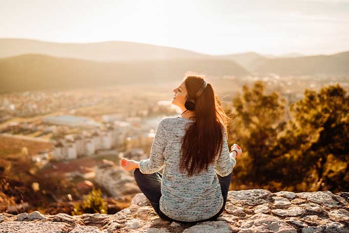Image of a solo female traveller listening to a podcast