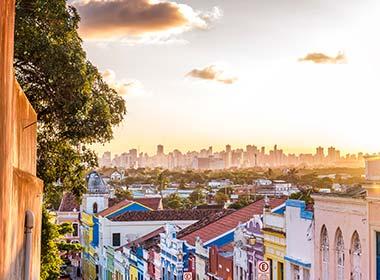overlooking town over hill with colouful buildings in olinda at sunset