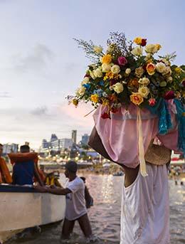 Iemanja, Brazil man carrying offerrings of flowers to the sea goddess for Iemanja