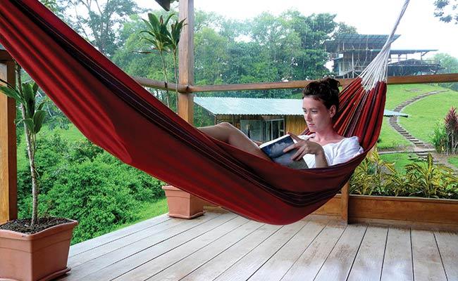 Solo female traveller at beautiful bay of Lake Atitlan with view to Volcano San Pedro