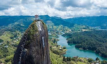 solo traveller standing on top of rock in guatape colombia