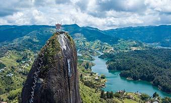 Best time to visit Guatape, Colombia solo traveller standing on top of rock in guatape colombia