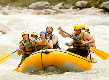 A group tour to Costa Rica, people in a raft white water rafting down the river in Turrialba