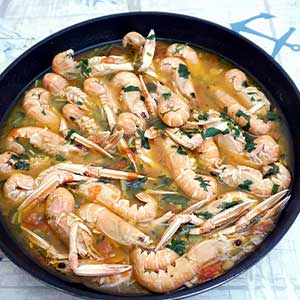 a pan of shrimps cooking in garlic and juices