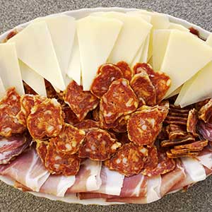 A platter of sliced pag cheese and cured meats