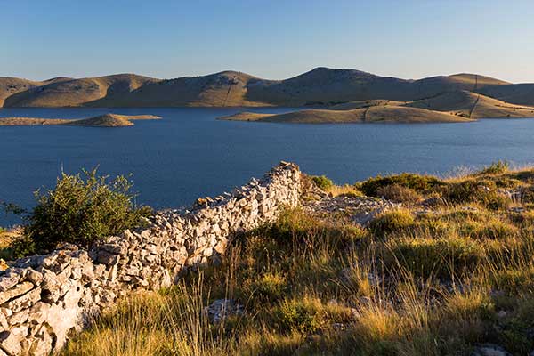views of the sea and other island from a grassy and barren island in Kornati national park in croatia