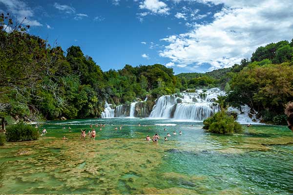 Krka National Park, Croatia visitors swimming in the lagoon below Krka waterfalls in Croatia