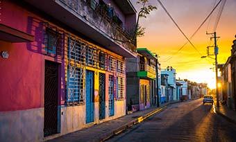 Visit Camaguey on a group tour to Cuba colourful buildings at sunset on backstreets of camaguey cuba