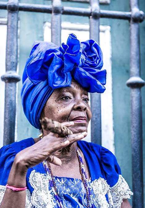 Cuban woman smoking a Cuban cigar cuban woman wearing blue with blue headscarf smoking a cuban cigar