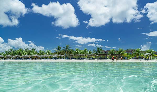 Playa Los Cocos, Cuba clear turqoise sea and white beach palm trees in cuba playa los cocos beach in cuba