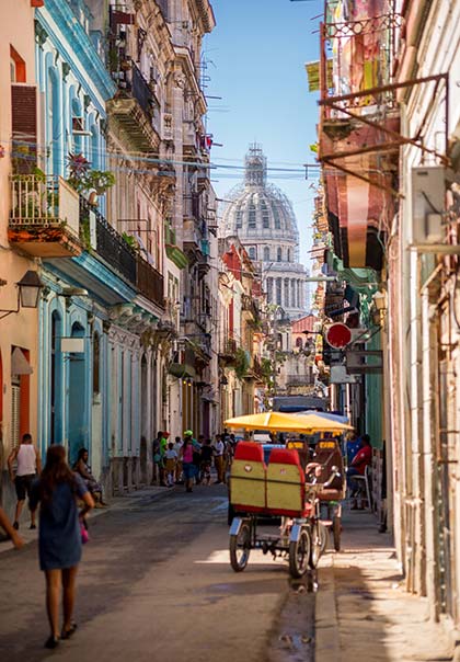 Old Havana, Cuba colourful buildings in streets of old havana cuba with rickshaw