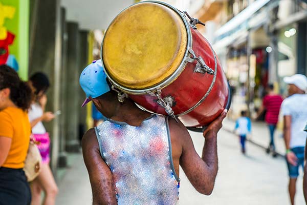 Havana Carnival, Havana Cuba man carrying red drum on his back at havana carnival cuba