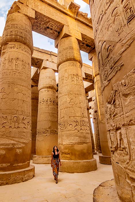 Woman exploring ancient Egyptian ruins woman walking around egyptian ruins exploring on a group tour in egypt