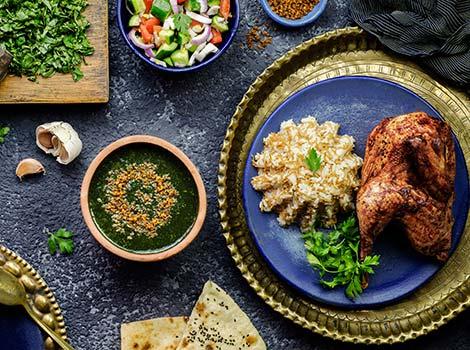Traditional Egyptian food of Molokhya or Molokhai Egyptian dish Molokhya or Molokhia with rice chicken pita bread oriental green salad crispy fried garlic