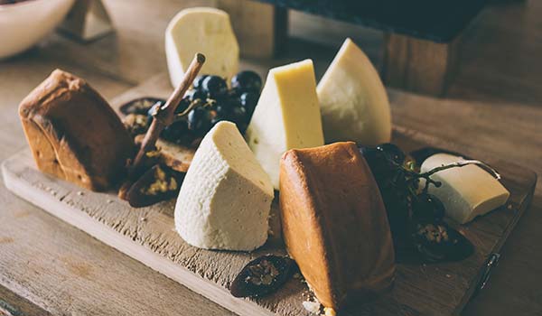 wooden board with a variety of georgian cheese and grapes