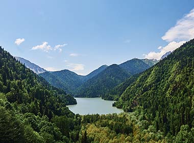 green forests and hills along the lake ritsa