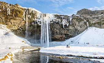 Seljalandsfoss Waterfall in winter, Iceland group tour to iceland in winter to see best waterfall in iceland frozen seljalandsfoss waterfall