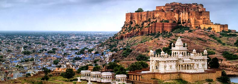 ancient fort of jaipur with palaces and blue painted houses below