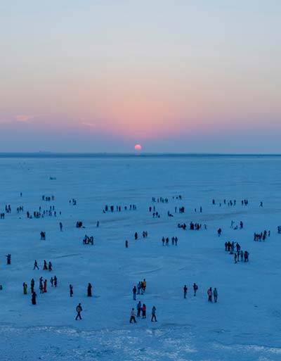 a group of people watching the sunset at rann of kutch salt flats in india