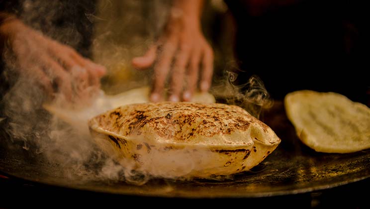 Traditional street food - cooking chapatis street food vendor making fresh chapatis in india