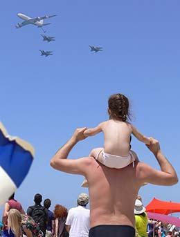 man holding girl on shoulders for israel festival