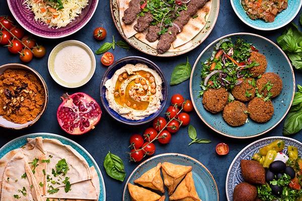 table spread of traditional israeli food on a grey table