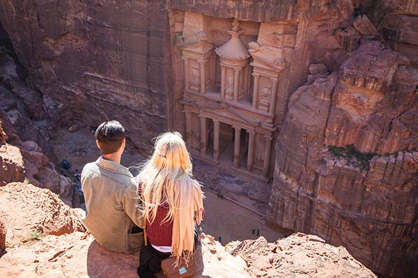 two people on a group tour visiting the ancient city of petra jordan