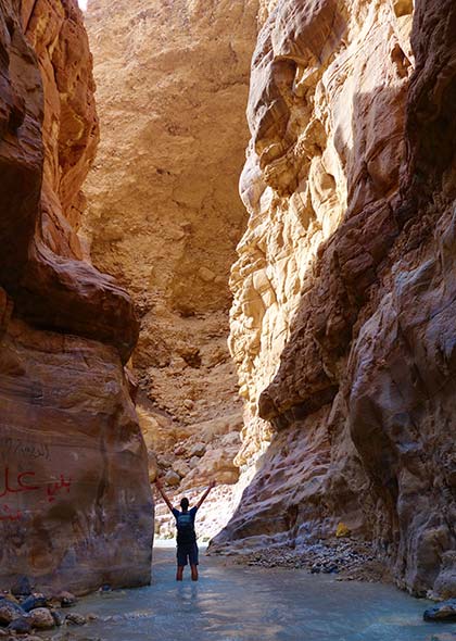 solo traveller standing inside gorge in jordan on a group tour