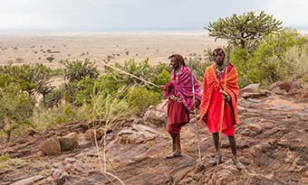 Kenya Travel Advice two kenyan people dressed in tribal clothing no the desert planes of kenya