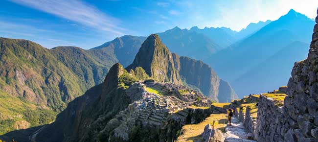 honeymoon couple on holiday are exploring the ancient ruins of machu picchu in perfect weather conditions