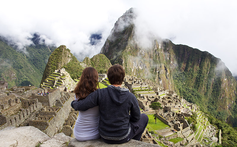 tailor-made honeymoons with tucan travel couple on honeymoon sitting in front of Machu Picchu