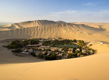 Visit a hidden oasis in Huacachina when on an adventure holiday Sand dunes lagoon oasis desert une buggy, adventure holiday group tour to the deserts in Peru