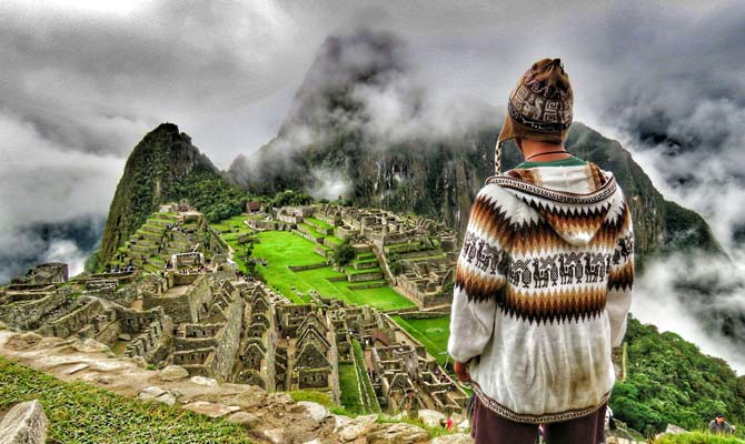 adventure travel tourist completes the Inca Trail with the reward of overlooking the stunning Machu Picchu