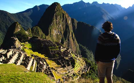 Solo tourist overlooking Machu Picchu Solo travellers amazed by his surroundings as he overlook's the ancient Machu Picchu ruins