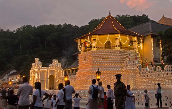 Sri Lankan Esala Perhera is held in Kandy - Holiday travelers photo of the sacred tooth relic lit up with lights at sunset